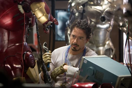 Tony Stark surrounded by different versions of his armor