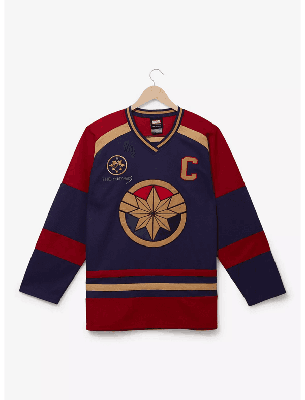 Shop it <a href=https://www.boxlunch.com/product/marvel-the-marvels-carol-danvers-hockey-jersey---boxlunch-exclusive/20560904.html>here</a>