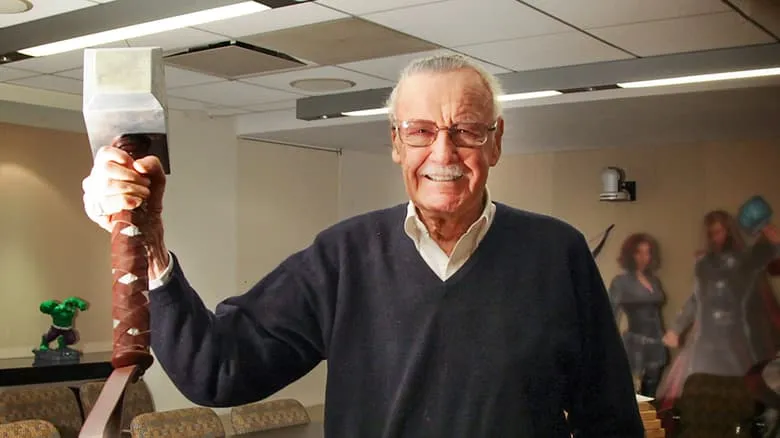 Stan Lee holding Thor's Might Hammer Mjolnir in the Marvel Office