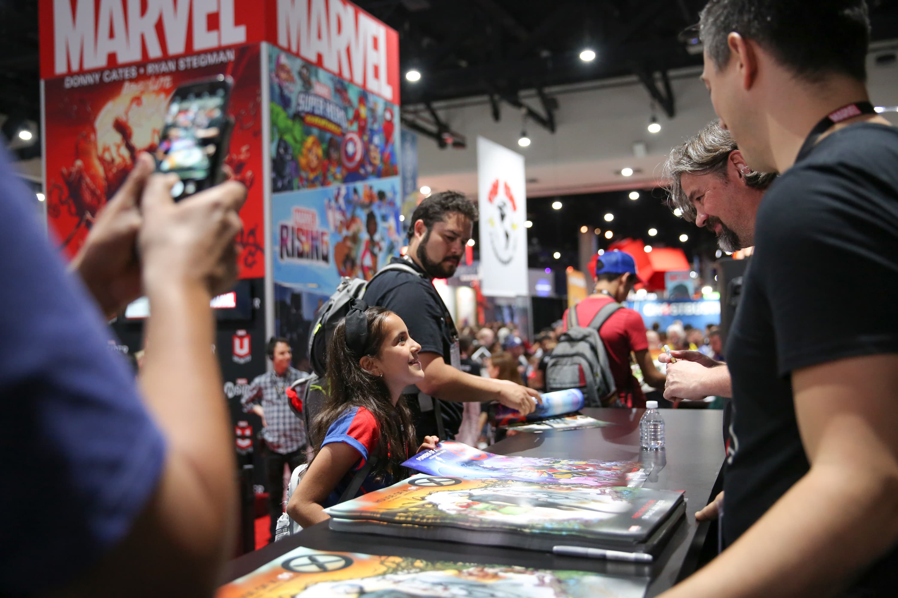 A young fan gets an autograph from Marvel creator Jonathan Hickman