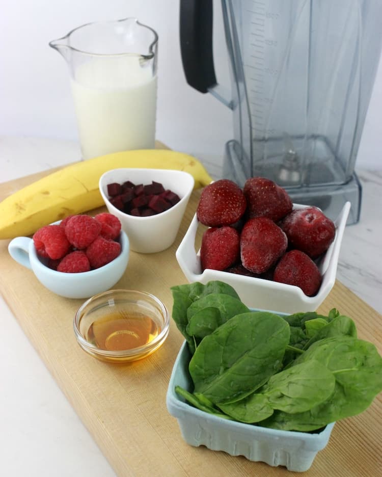 In a blender, add the almond milk, banana, frozen strawberries, spinach, beets, raspberries, and honey. Blend well.